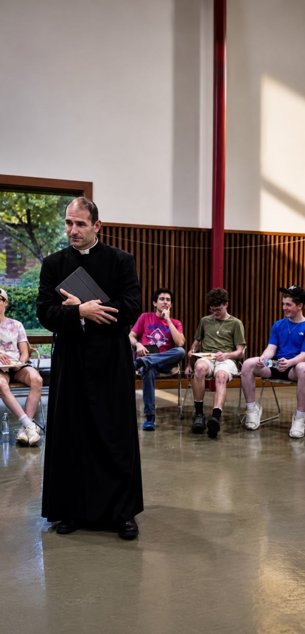 A priest speaking with young men at a Sons of Joseph formation gathering